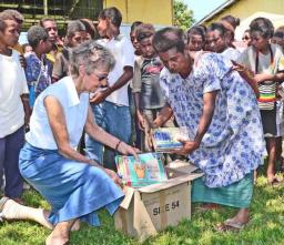 Maureen Hill and a teacher from the Holy Cross Merio Primary School opening on of the boxes of books