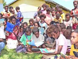 Excited children with donated books.