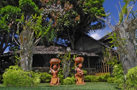 Two spirit figures in an orchid garden at Madang Lodge