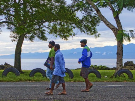 Boys walking along Coronation Drive with the Finisterre Mountains in the background